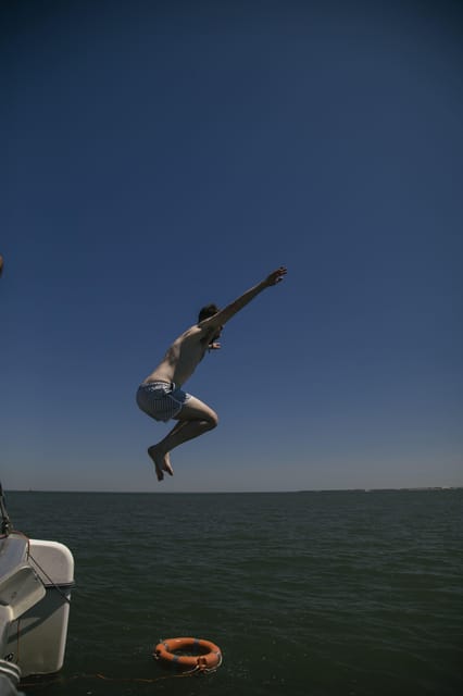 Lisbon: Catamaran Boat Party with Music, Open Bar & Dives - Deck dancing, water access from a ladder, and staying comfortable