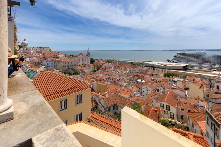 Alfama rooftops falling away to the Tagus