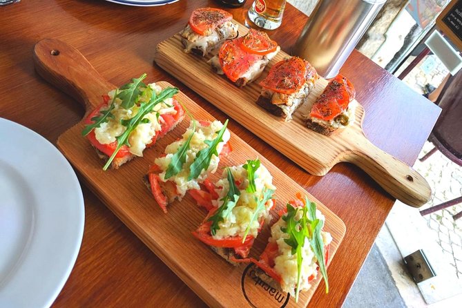 Lisbon Small-Group Food Tour with 18 Tastings in Alfama District - Stop 1 in Alfama: Small Plates, Wine, and Sea-to-Land Variety